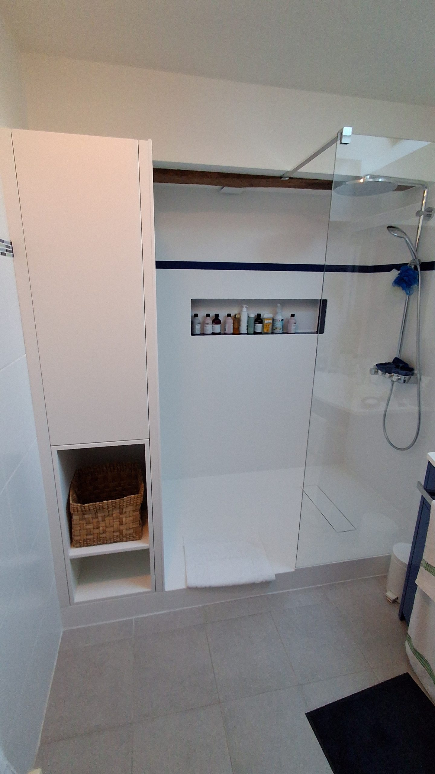 Réfection de la baignoire en douche . Douche en corian blanc avec liseret bleu et d'un meuble colonne de salle bain sur mesure 