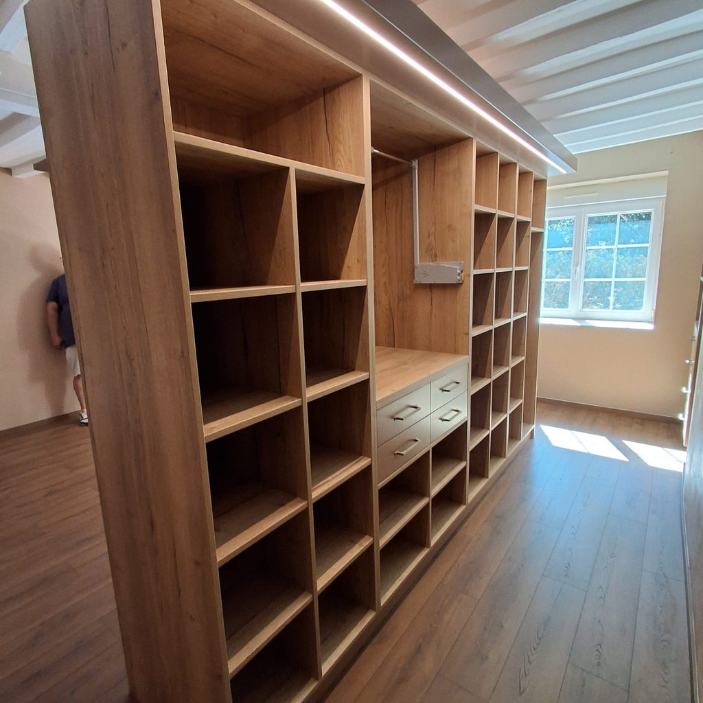 Aménagement de chambre sur mesure avec tête de lit et au dos un dressing ouvert